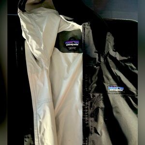 Black Patagonia rain jacket. Lightweight and versatile.